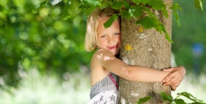 Mädchen umarmt einen Baum