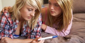Zwei Mädchen betrachten besorgt einen Schwangerschaftstest