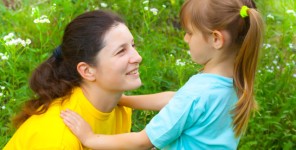 Eine Mutter spricht mit ihrer kleinen Tochter auf Augenhöhe