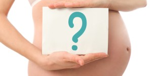 Eine Tafel mit mit einem Fragezeichen vor einem Schwangerschaftsbauch 